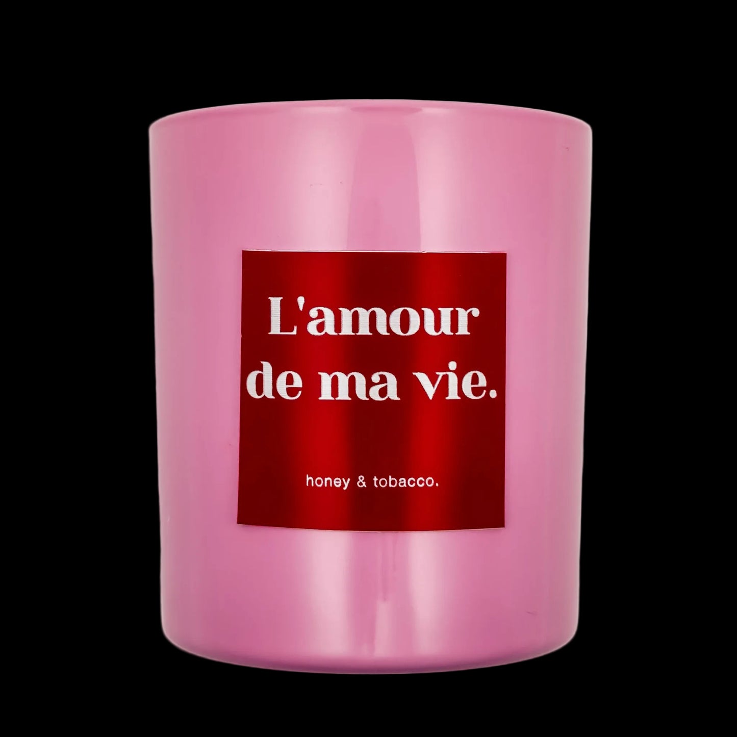 Pink candle with a red label displaying 'L'amour de ma vie' on a black background
