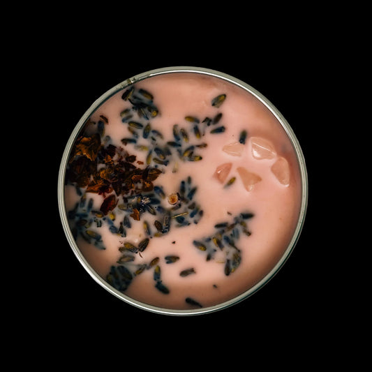 Round container with pink contents and dried herbs on a black background